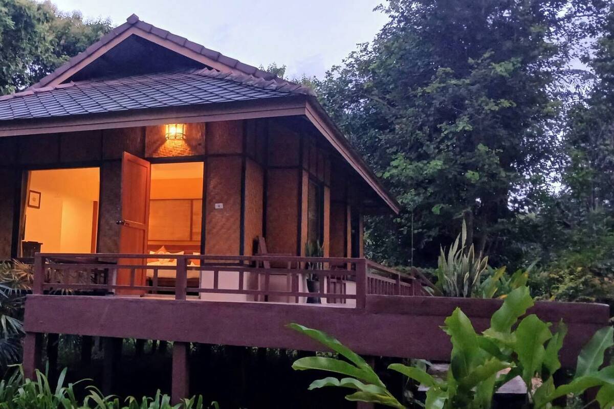 Uma casa de madeira com varanda e interior iluminado.