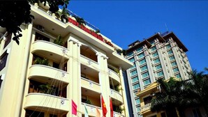 A multi-story hotel with balconies, a prominent entrance, and a flag display. - Duy Tan Hotel (Hue)