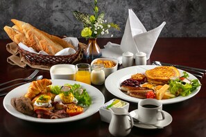 A breakfast setting with croissants, eggs, bacon, pancakes, and a fruit salad. - The Tray Hotel Hai Phong (Hai Phong)