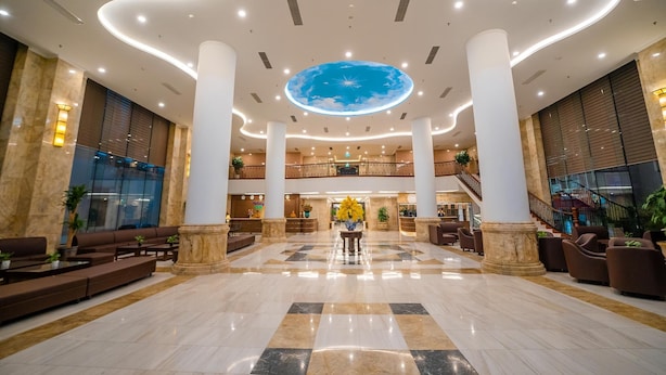 En rummelig lobby med et centralt atrium, store søjler og et loft med himmeldesign.