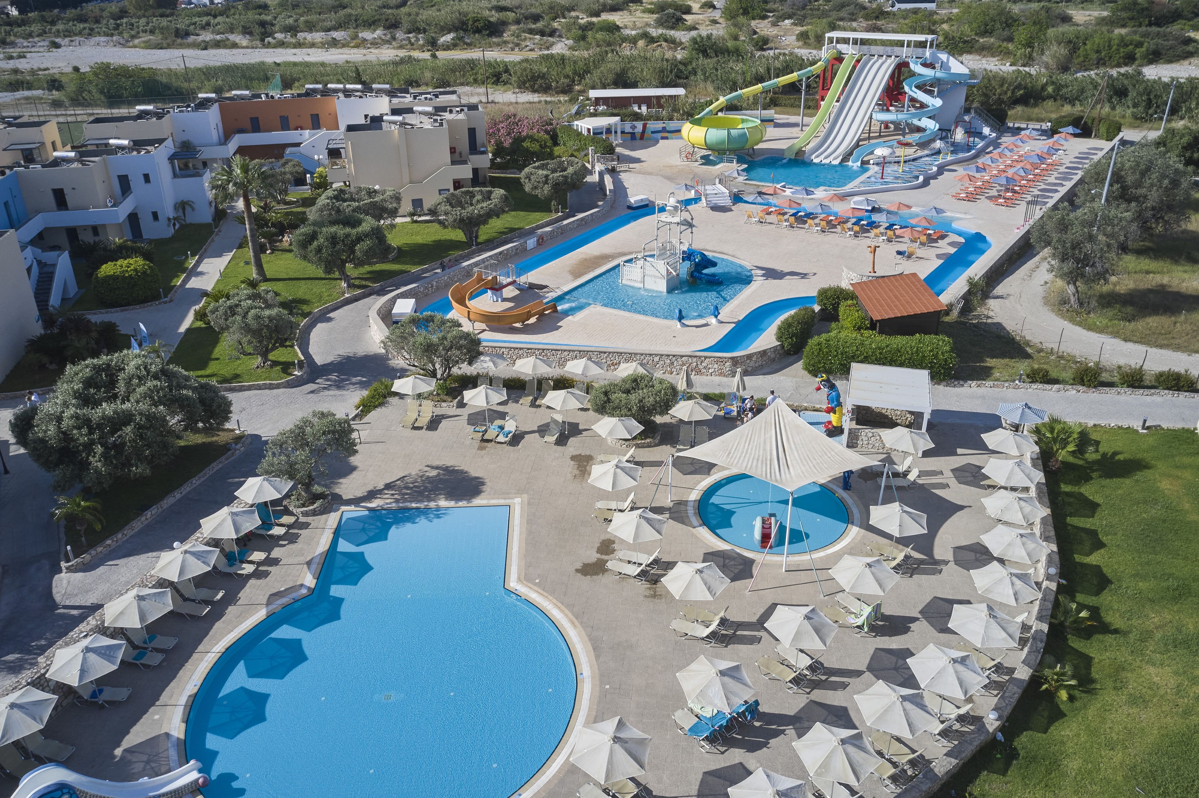 A resort with multiple swimming pools, a water slide, and sun loungers.