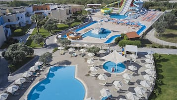 A resort with multiple swimming pools, a water slide, and sun loungers.