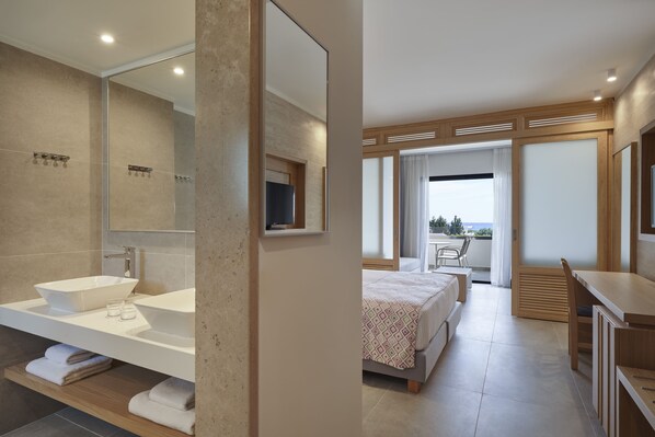 Un baño moderno con un espejo grande, un lavamanos blanco y una bañera.
