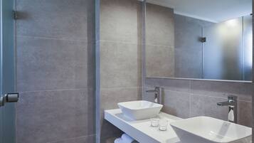 Un baño moderno con dos lavamanos, un espejo y un perchero para toallas.