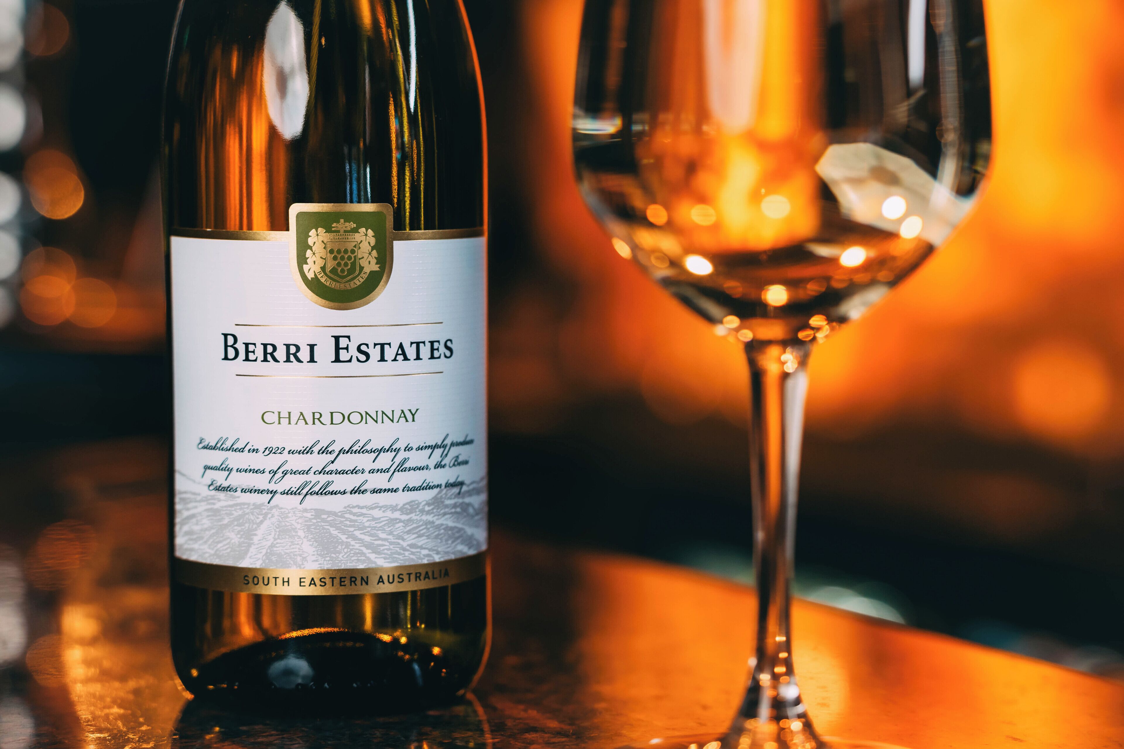 En flaska Berri Estates Chardonnay och ett vinglas på en bardisk.