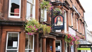 Un bâtiment traditionnel avec une enseigne indiquant « The George Hotel » et une autre, à proximité, indiquant « Arcade ».