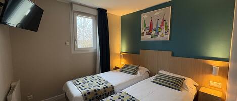 A hotel room with two beds, a TV mounted on the wall, a window with curtains, and a painting of sailboats.