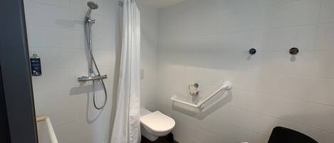 A modern bathroom with a shower, toilet, and a towel rack.