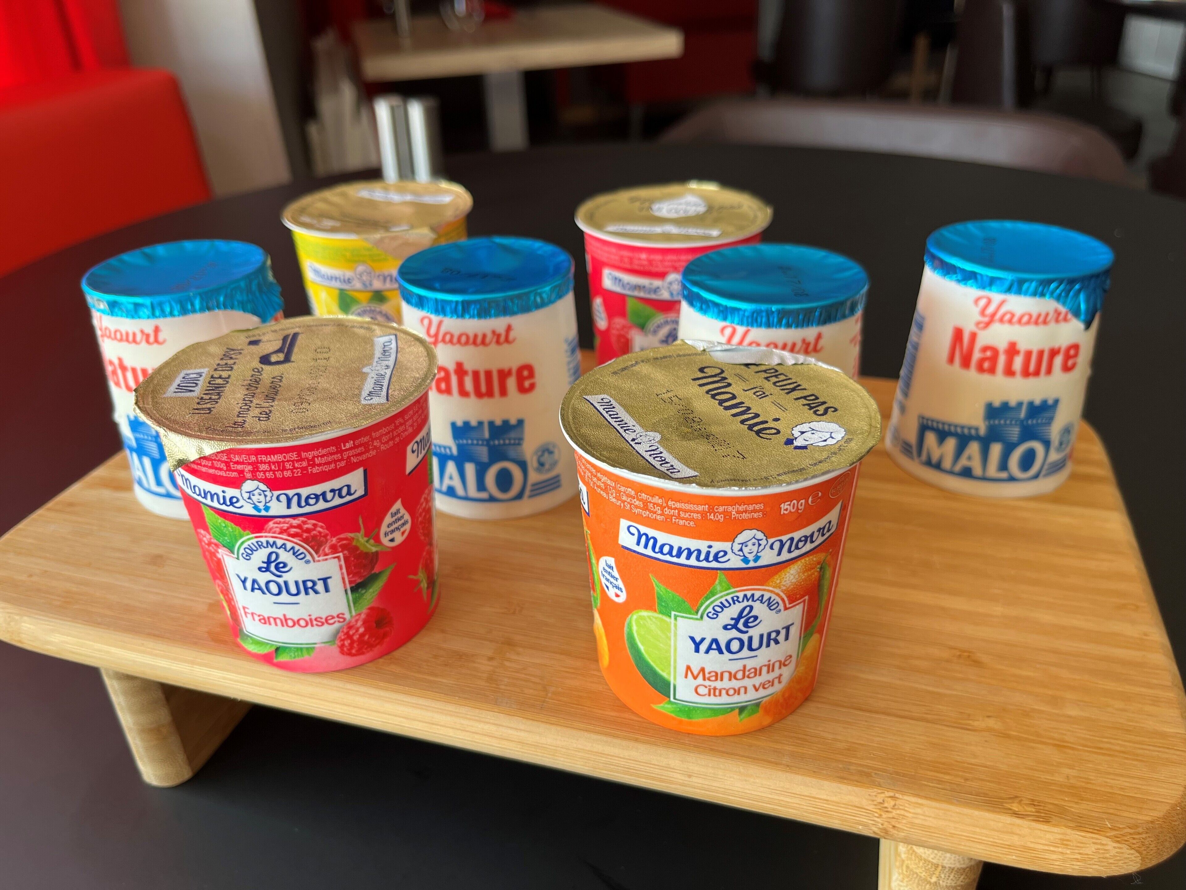 A wooden table with several containers of yogurt.