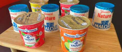 A wooden table with several containers of yogurt.