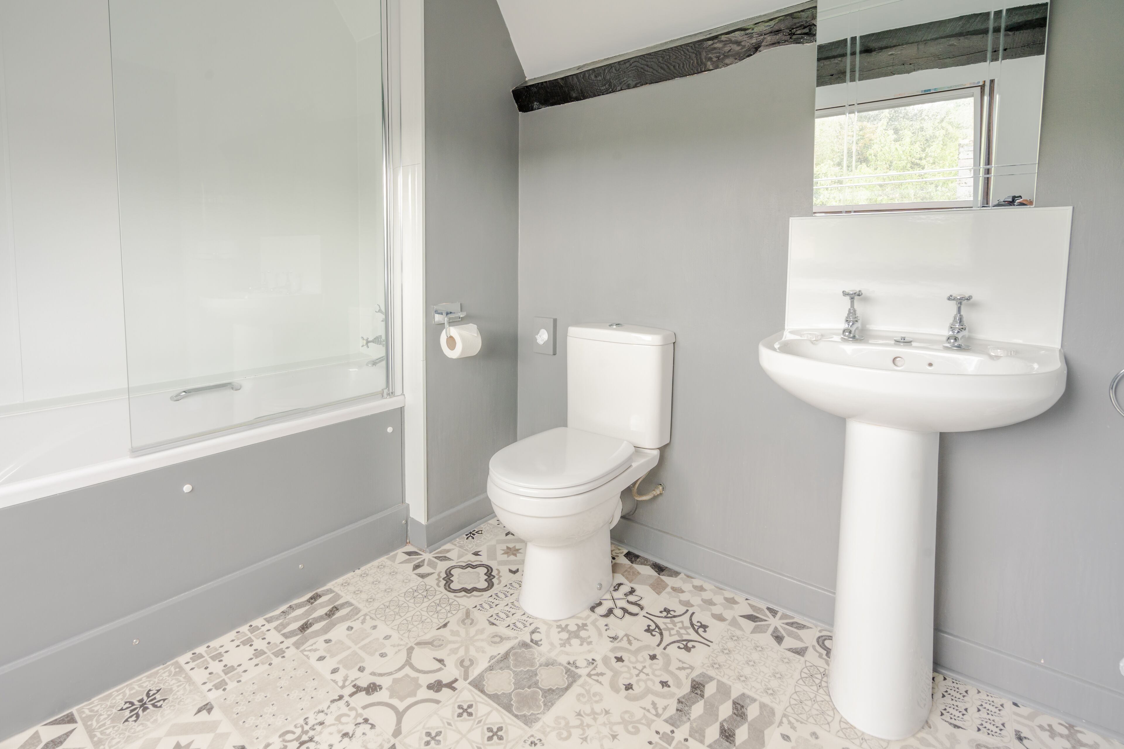 A bathroom with a toilet, sink, and shower.