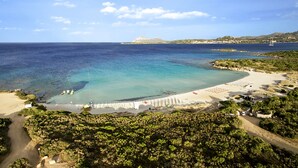 A coastal beach with a clear blue sea, a sandy shore, and a white fence along the beach. - Colonna Hotel Du Golf (Olbia)