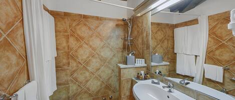 A bathroom with a large sink, mirror, and shower.