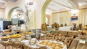 Ein reichhaltiges Buffet mit verschiedenen Speisen sowie ein Tisch mit Tellern und Servietten.