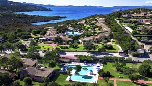 Ein Resort mit einem zentralen Pool, Gästezimmern und Meerblick.