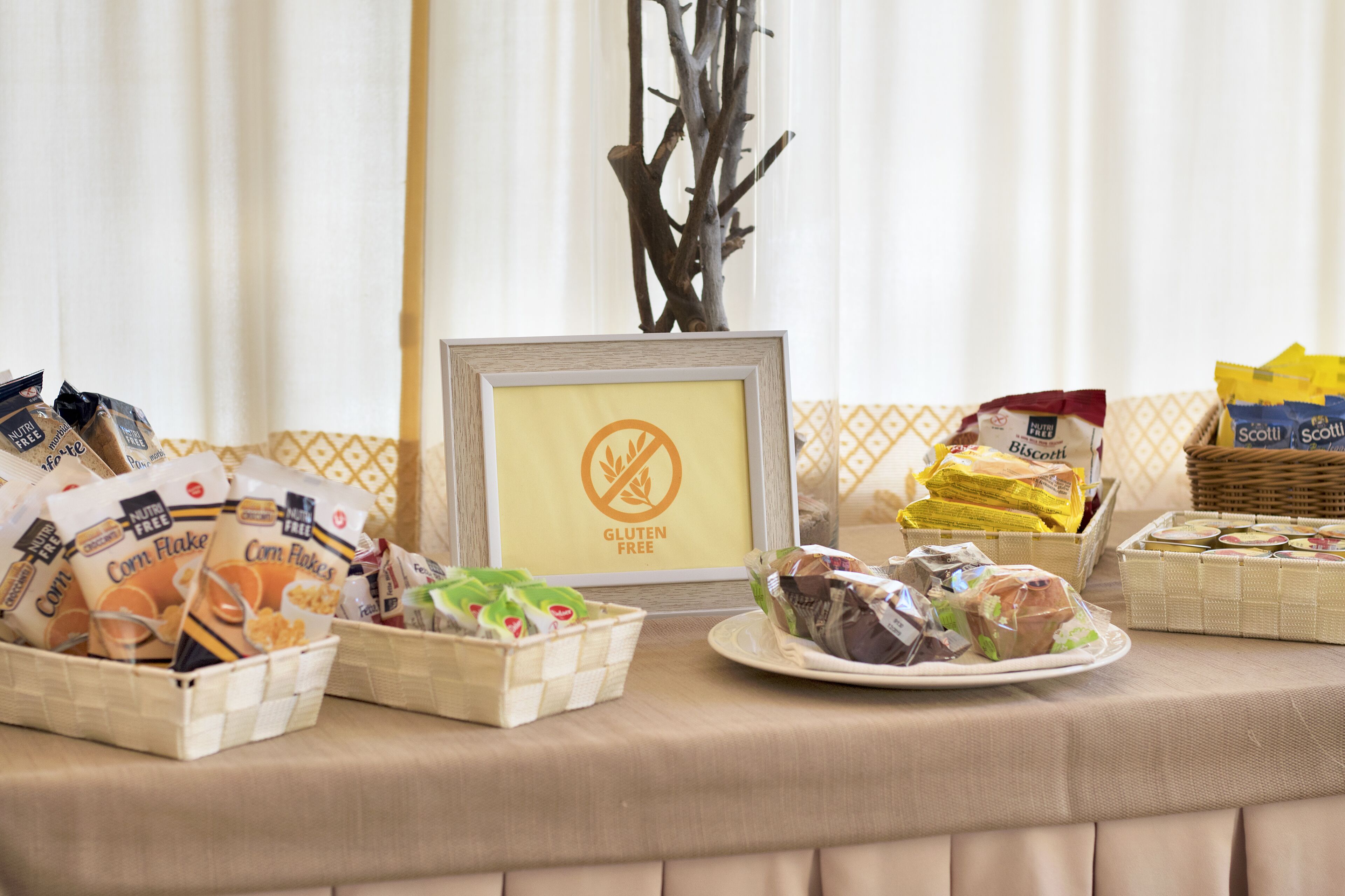 Une table de buffet proposant divers plats, notamment des options sans gluten, des céréales de maïs et des biscuits.