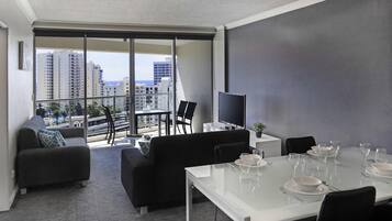 A modern living room with a balcony, a dining area, and a TV.