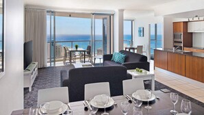 A modern hotel room with a balcony, a dining area, and a kitchen. - Mantra Towers of Chevron (Surfers Paradise)