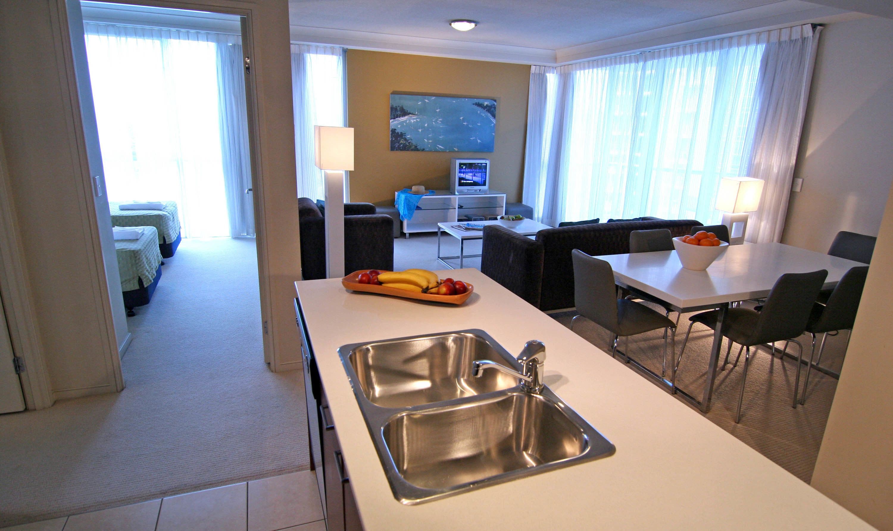 Een hotelkamer met kitchenette, eethoek en zithoek.