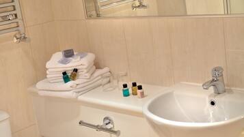 A bathroom with a white sink, a mirror, and a towel rack.