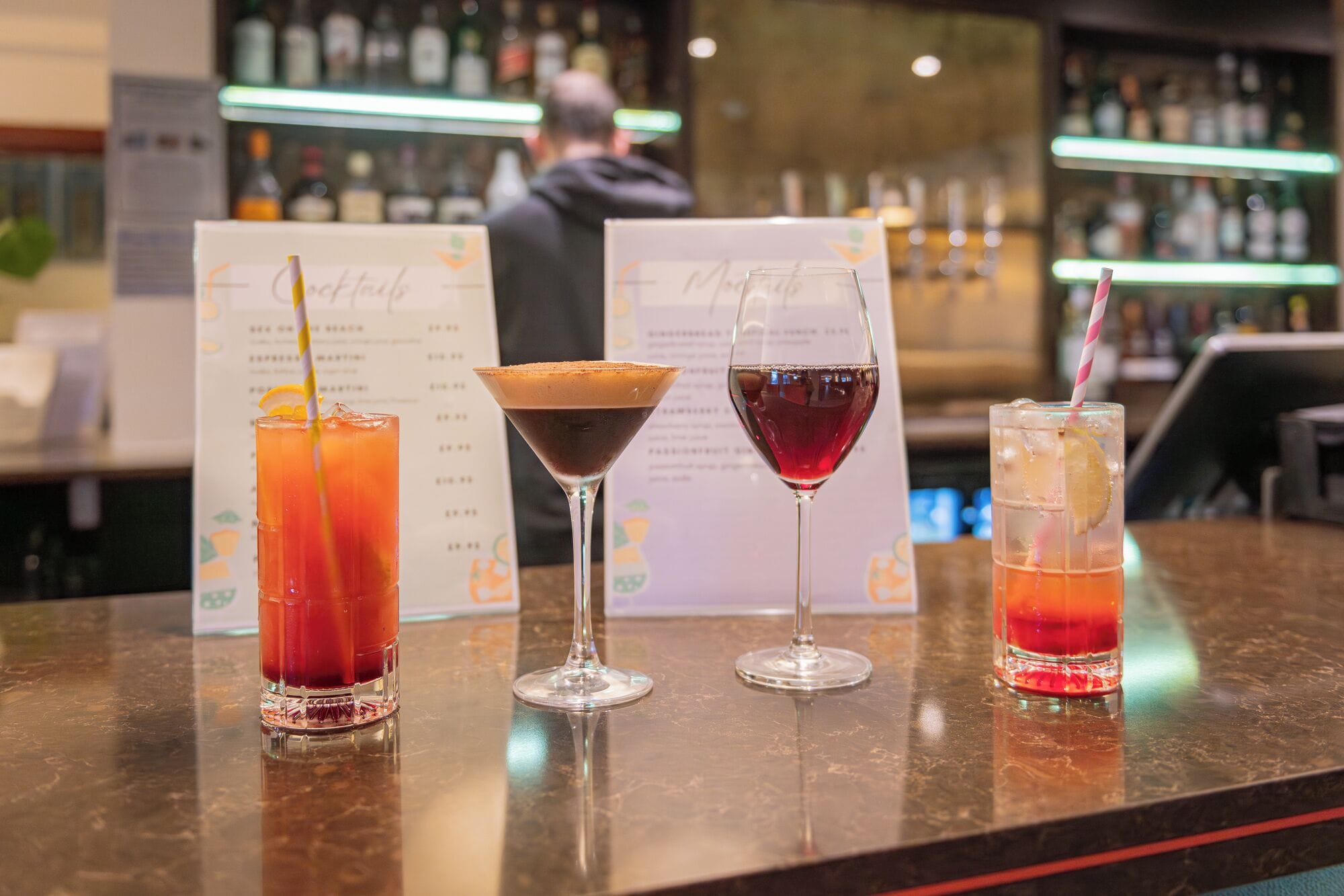 A bar area with three different drinks on the counter.