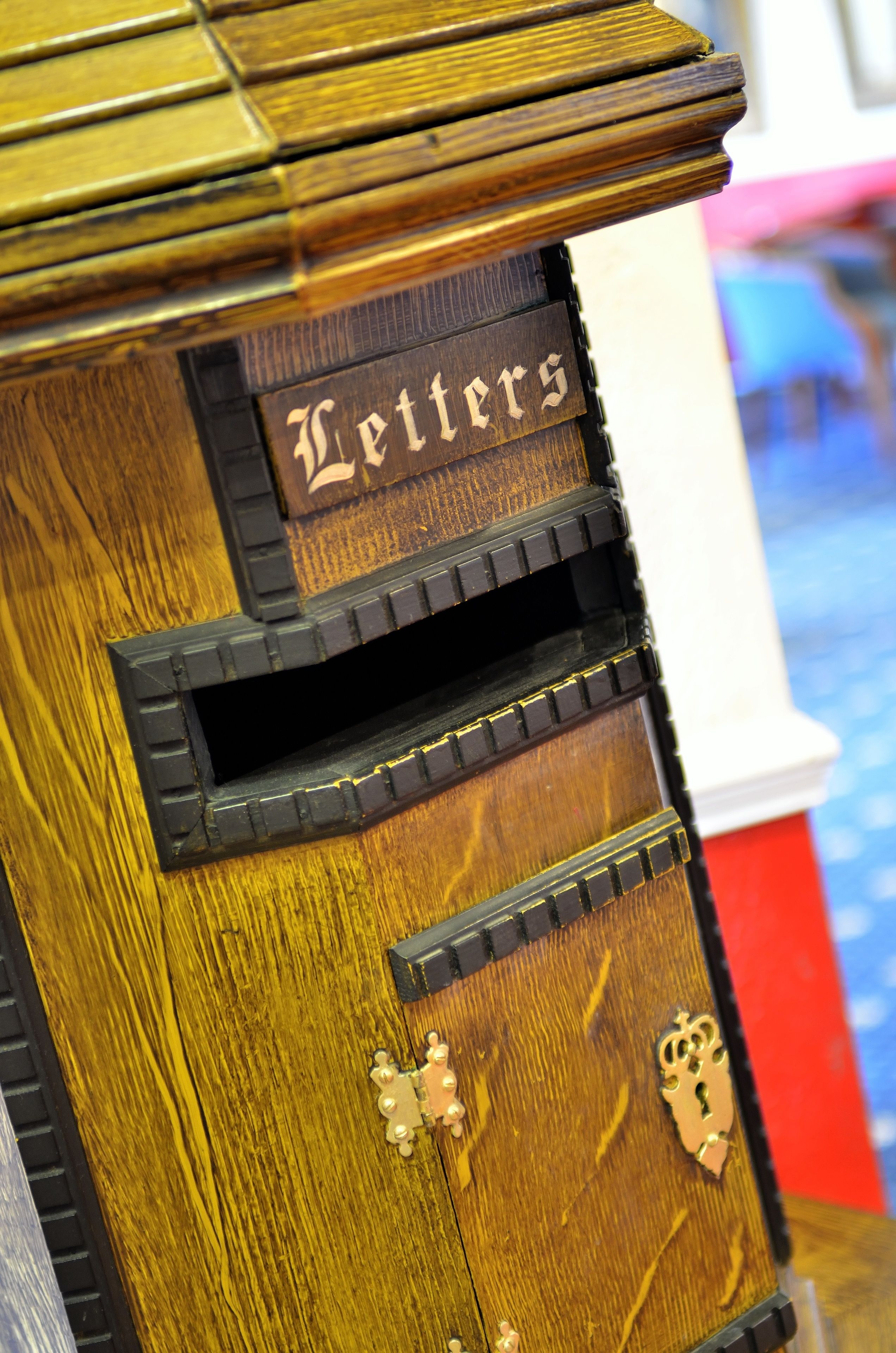 A wooden cabinet with a slot for letters and a plaque that reads "Letters".
