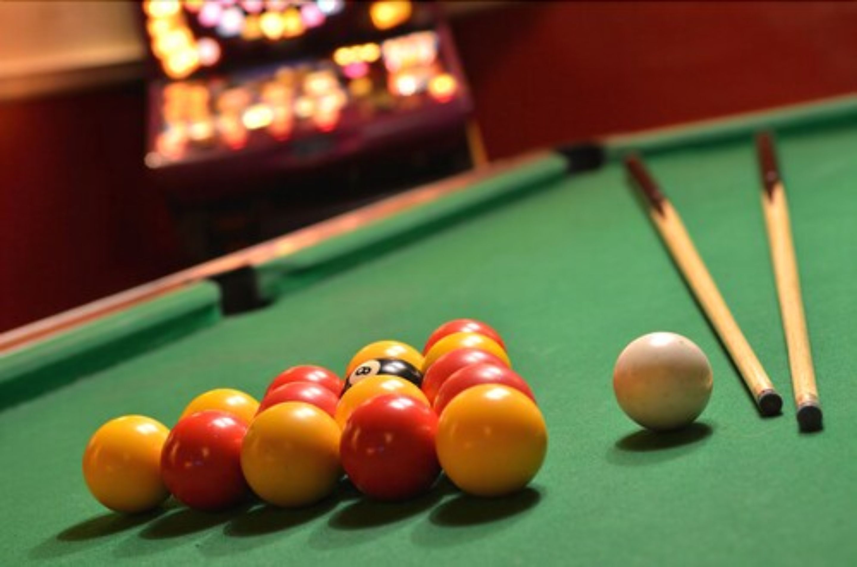 A pool table with billiard balls and cues.