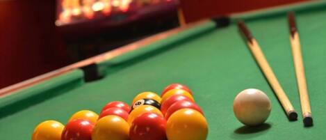 A pool table with billiard balls and cues.