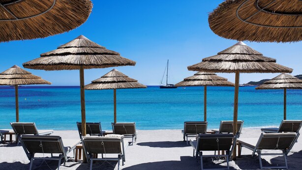 A beach with thatched umbrellas and lounge chairs facing the sea. - CPH - Pevero Hotel (Arzachena)