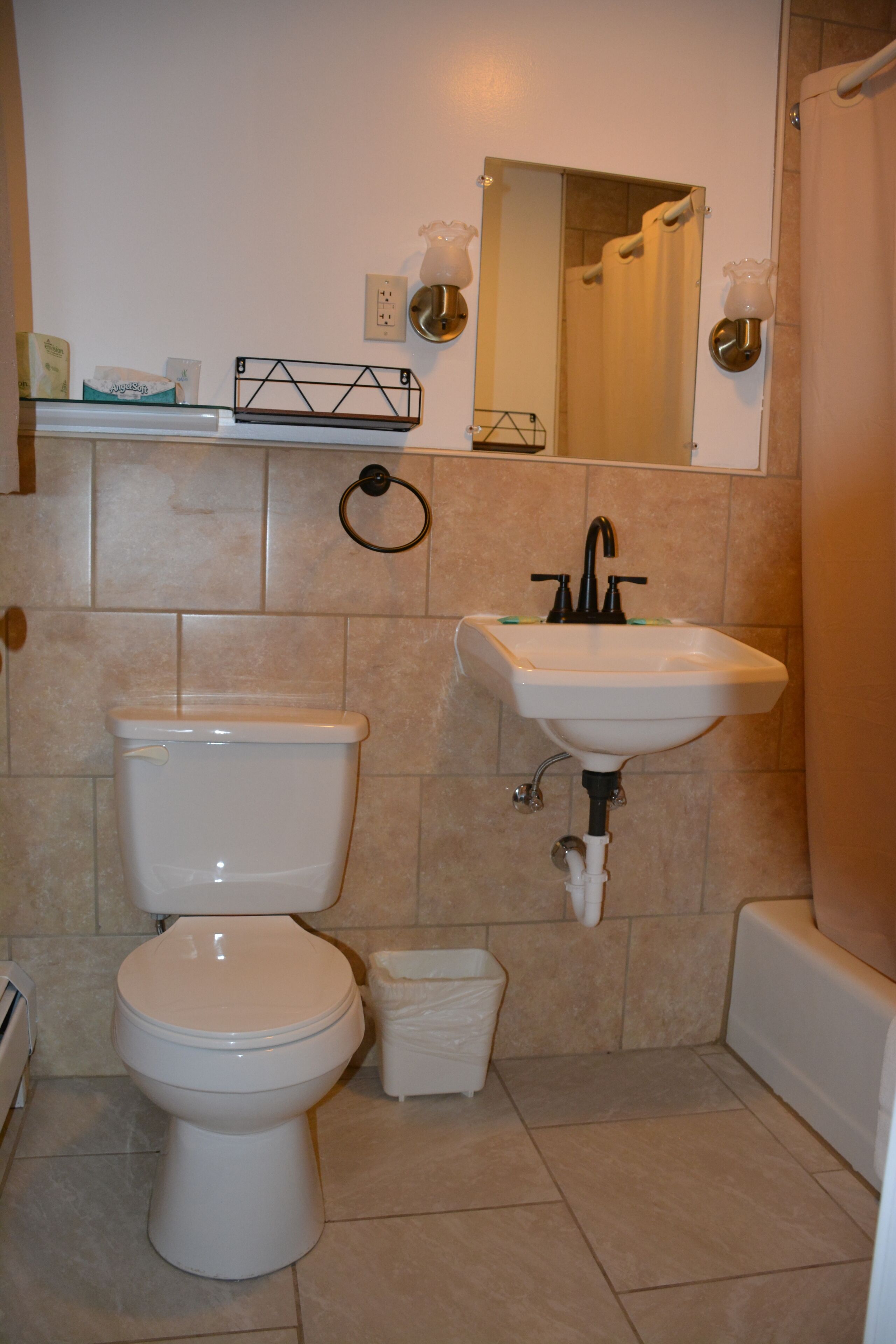 A bathroom with a toilet, sink, and shower.