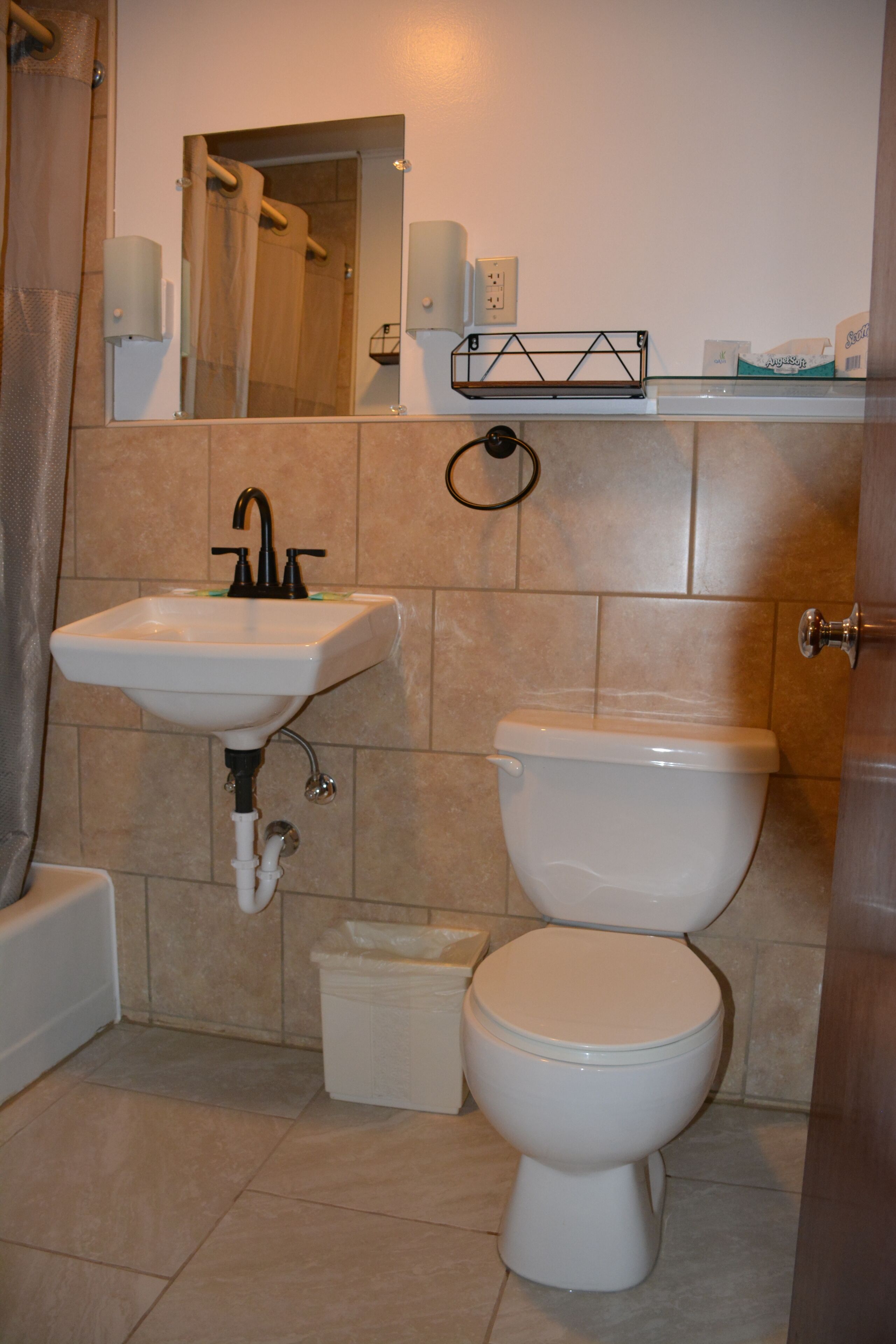 Un baño con lavamanos, inodoro y zona de ducha.