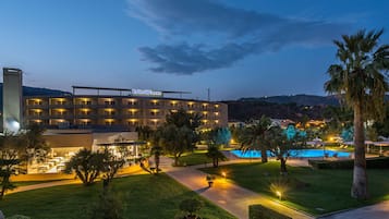 Experience the serene atmosphere of RADA SIRI, surrounded by lush greenery and a tranquil swimming pool.