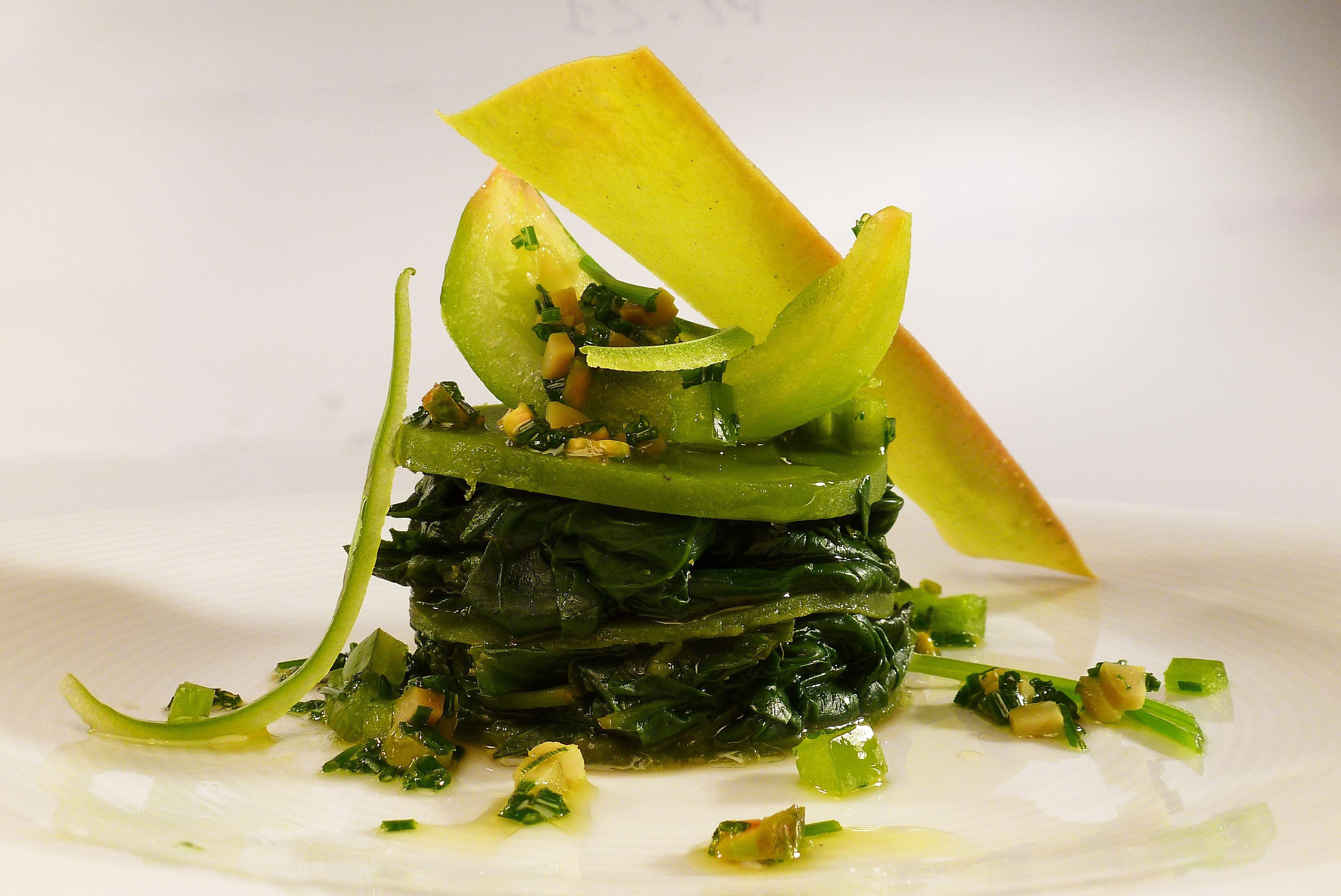 Un plato con vegetales de hoja y un elemento amarillo, posiblemente una verdura o fruta.