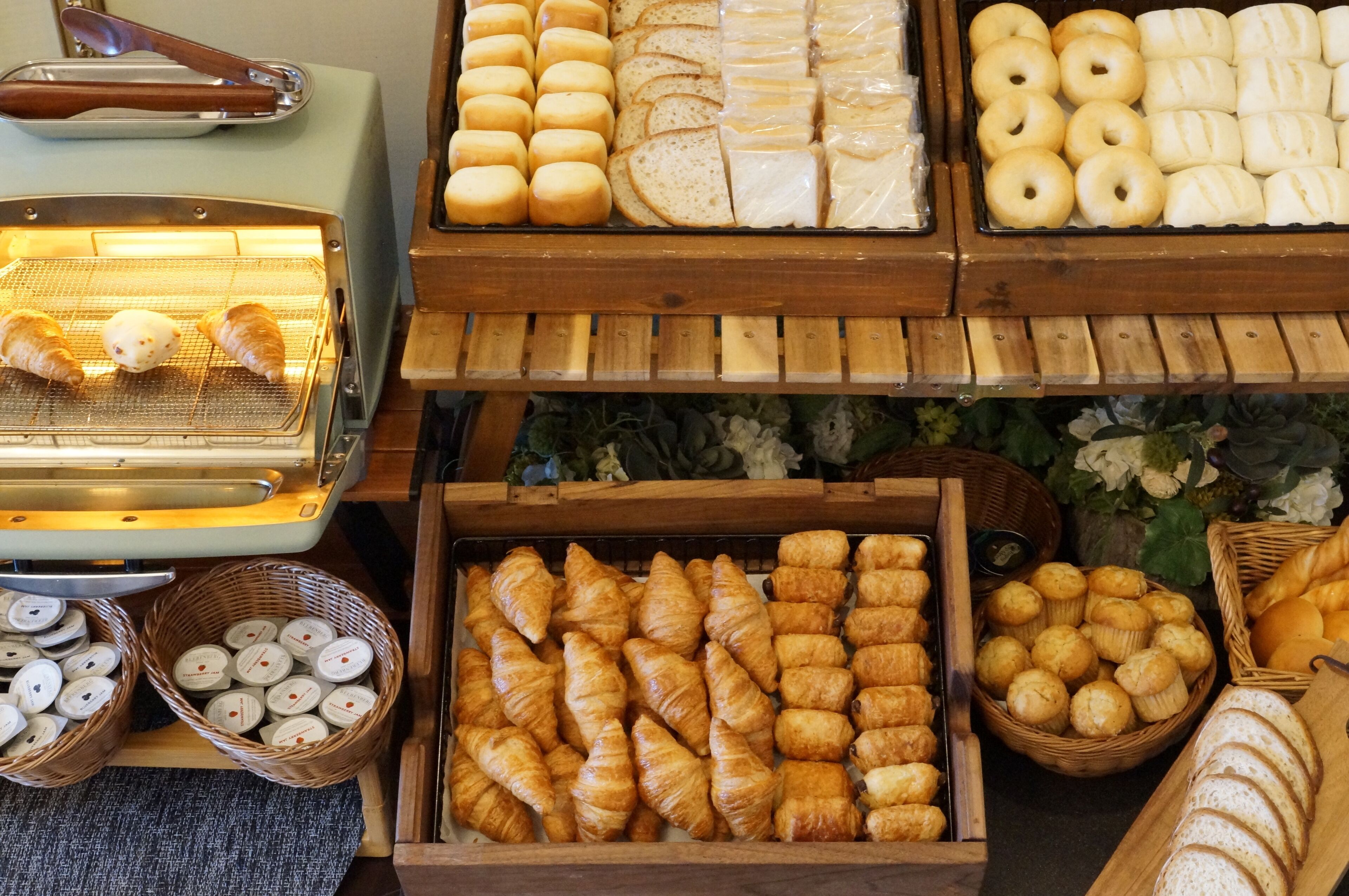 Una vitrina de panadería con diversos productos horneados, como cruasanes, muffins y pan.