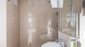 Un bagno moderno con doccia, lavandino e specchio.