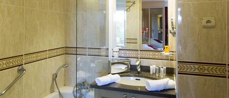 A modern bathroom with a glass-enclosed shower, a freestanding bathtub, and a vanity with a mirror.
