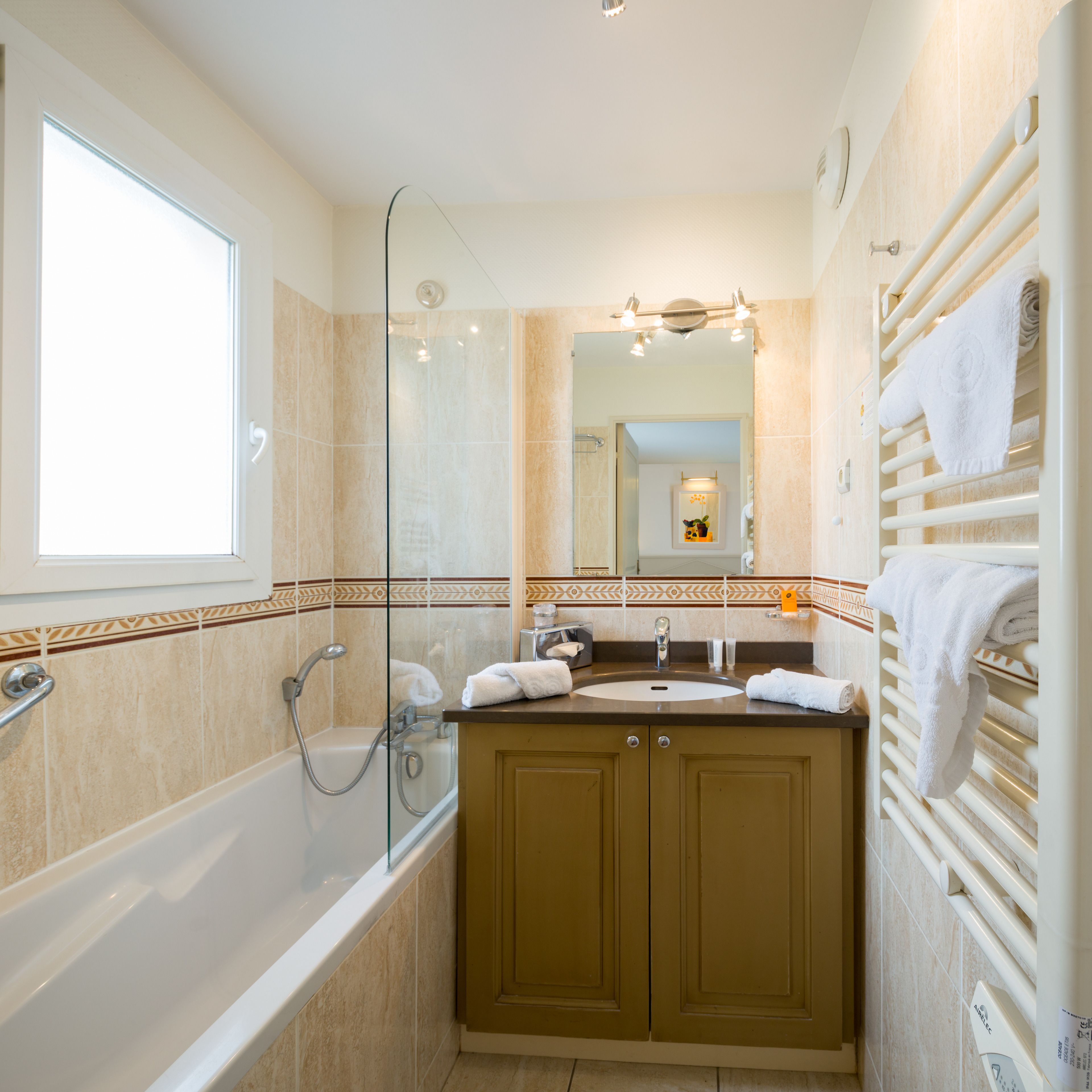 Une salle de bain moderne avec une baignoire, une douche à parois de verre et un meuble-lavabo avec un miroir.