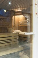 Una sala de sauna con bancos de madera y un reposapiés.