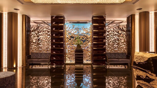 A spacious lobby with a reflective floor, a central seating area, and a decorative wall with a floral pattern. - Nobu Hotel Roma (Rome)