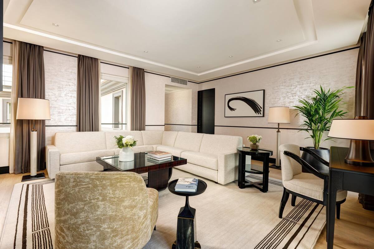 A modern living room with a sofa, armchair, coffee table, and side tables.