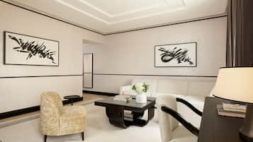 Un'area lounge moderna con divano, poltrone, tavolino da caffè e opere d'arte alle pareti.