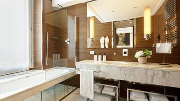 A modern bathroom with a glass-enclosed shower, a large mirror, and a marble vanity.