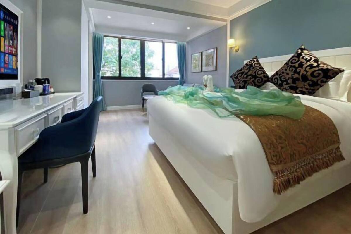 Ein modernes Hotelzimmer mit einem Bett, einem Schreibtisch und einem Stuhl.