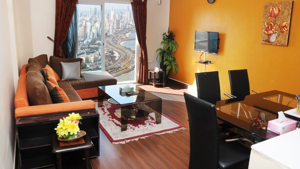 Una sala de estar moderna con sofá, mesa de centro y comedor.