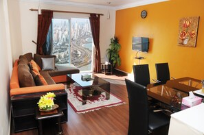 A modern living room with a sofa, coffee table, and dining area.