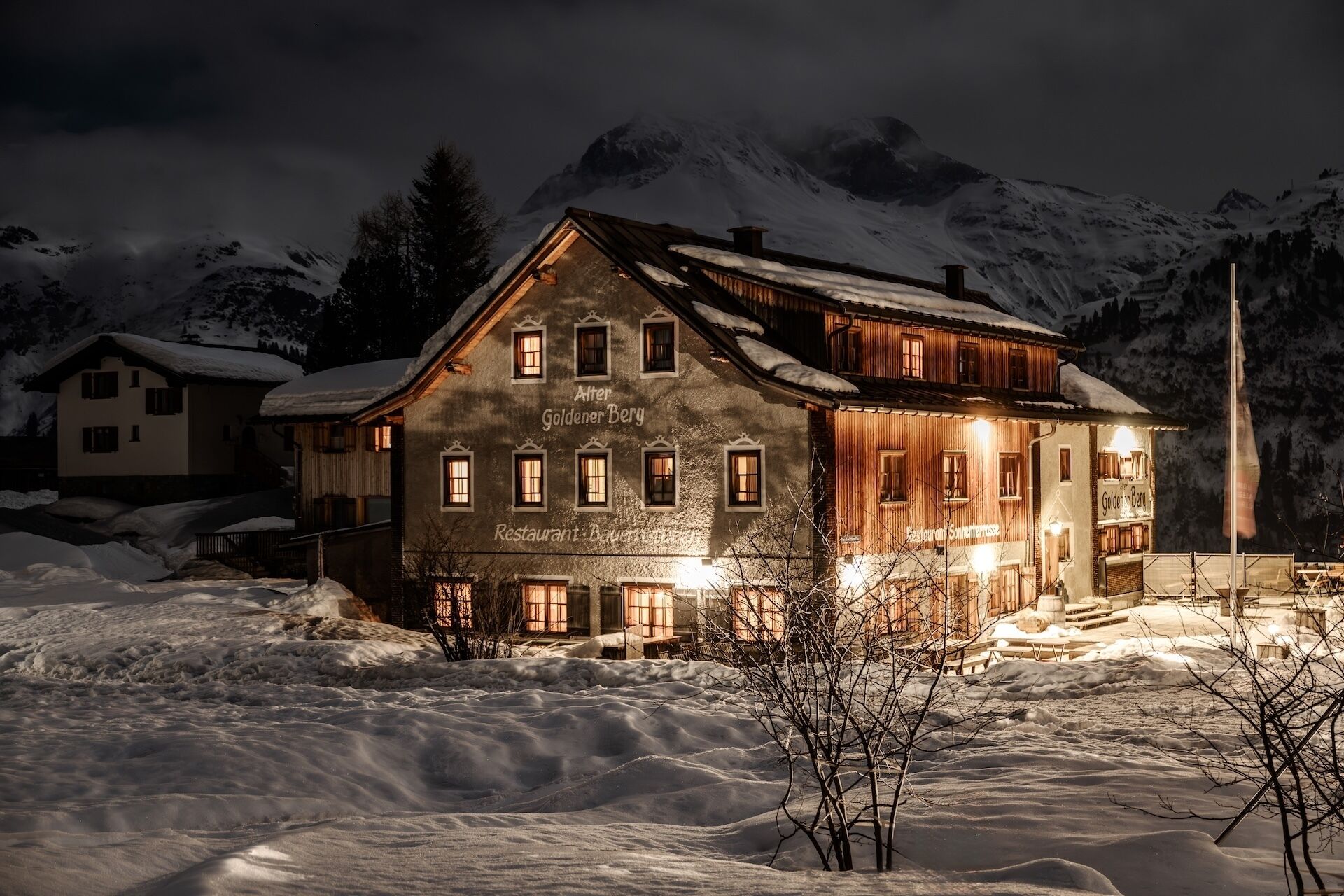 Un edificio grande de varios pisos con un letrero que dice 'Alber Goldener Berg Restaurant'.