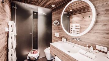 A modern bathroom with a wooden wall, a large mirror, a white sink, and a shower enclosure.