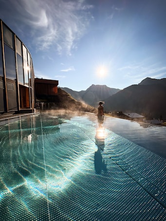 Una piscina techada, una piscina al aire libre, sombrillas