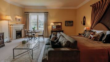 A cozy living room with a fireplace, a sofa, a dining table, and a bed.