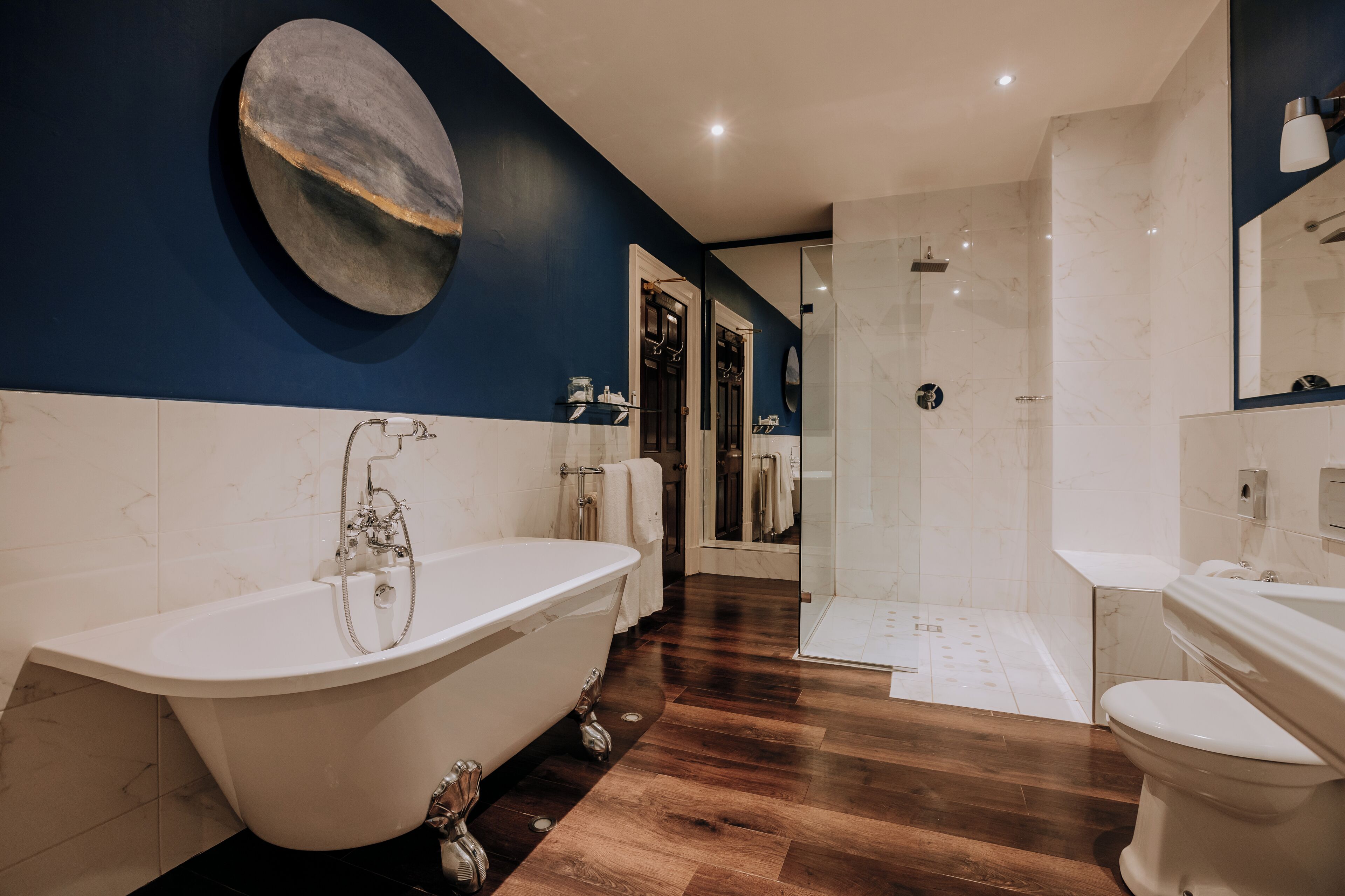 A modern bathroom with a freestanding bathtub, a walk-in shower, and a toilet.